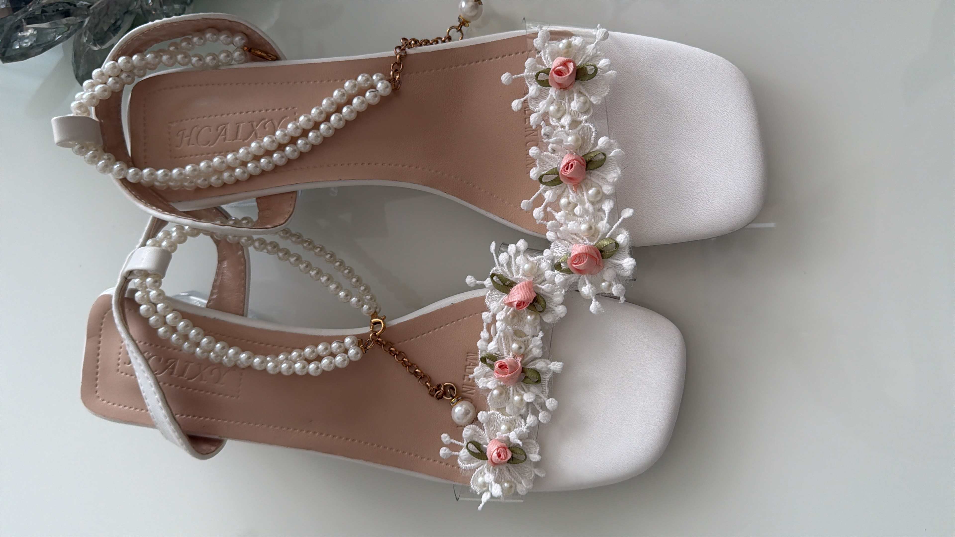Weiße Sandalen mit Perlen und Blumenapplikationen
